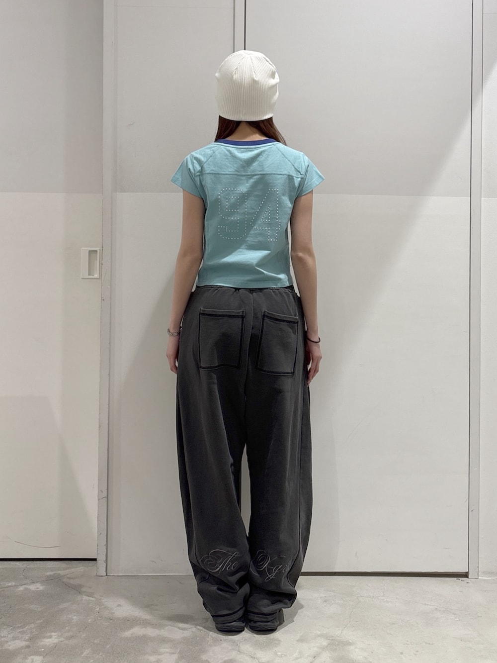 ブラック系のスウェットパンツ、ブラック系のパーカー、グリーン系のTシャツ/カットソーを着用したレディースの春コーディネートの5枚目の写真