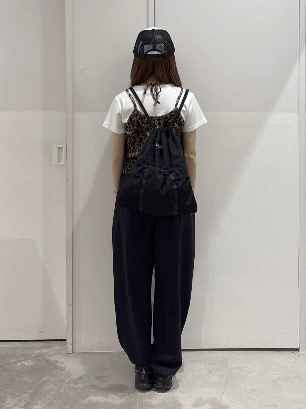ベージュ系のキャミソール、ホワイト系のTシャツ/カットソー、ブラック系のスウェットパンツを着用したレディースの夏コーディネートの4枚目の写真