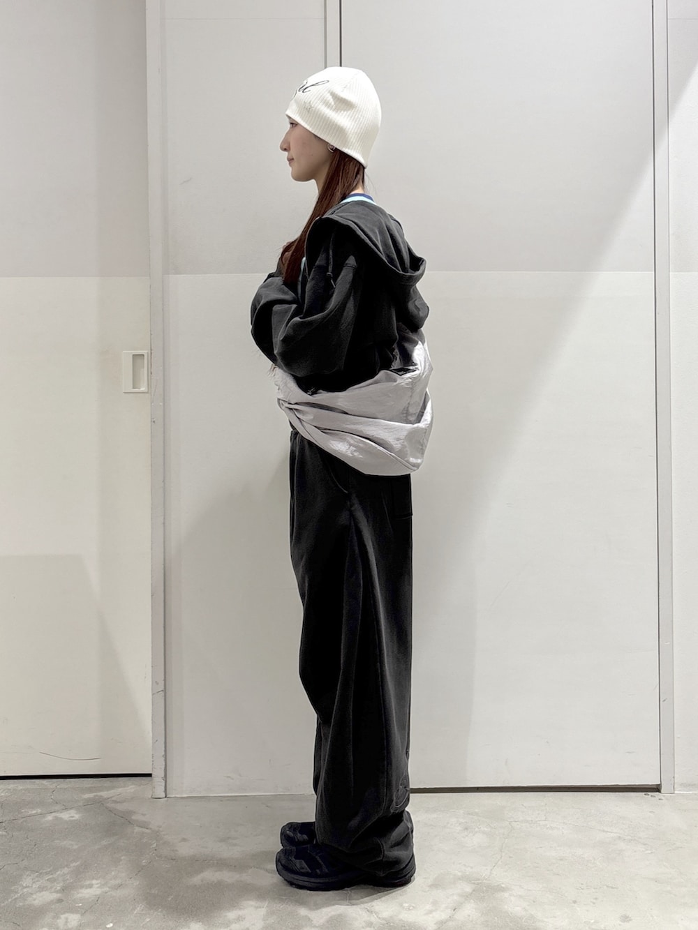 ブラック系のスウェットパンツ、ブラック系のパーカー、グリーン系のTシャツ/カットソーを着用したレディースの春コーディネートの2枚目の写真