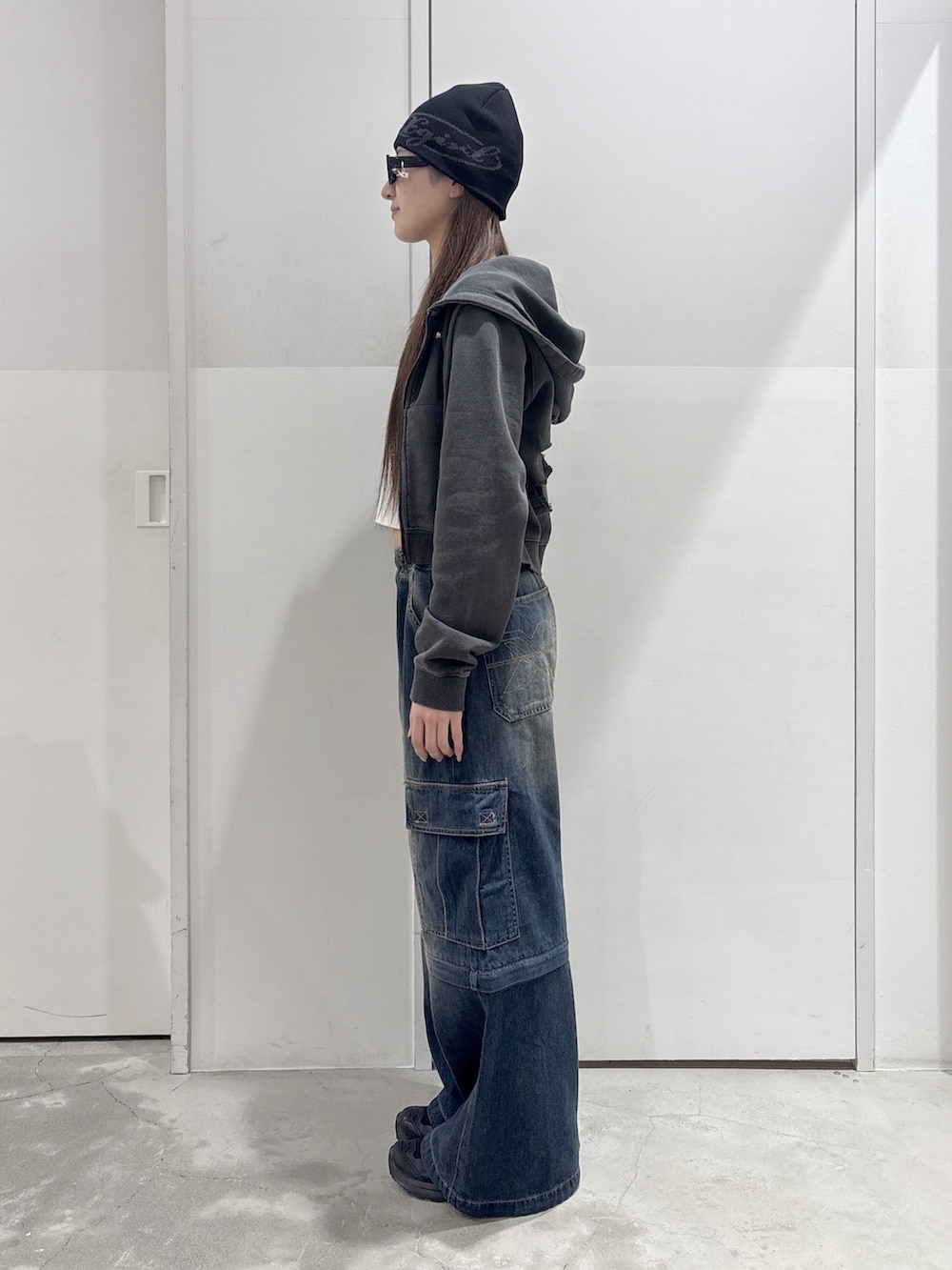 ブルー系のデニムパンツ、ホワイト系のTシャツ/カットソー、ブラック系のパーカーを着用したレディースの春コーディネートの2枚目の写真