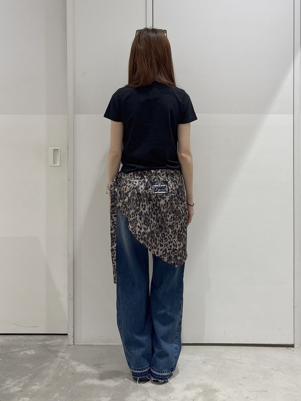 ブルー系のデニムパンツ、ブラック系のTシャツ/カットソー、ブラック系のショルダーバッグを着用したレディースの夏コーディネートの3枚目の写真