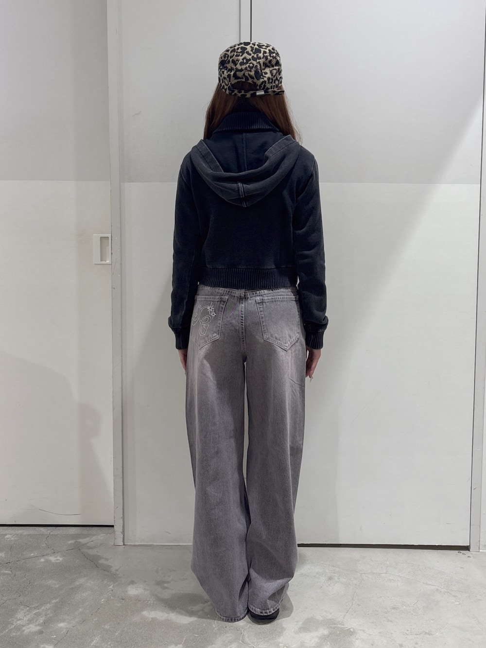 ピンク系のデニムパンツ、ブラック系のブルゾン、ベージュ系のキャップを着用したレディースの秋コーディネートの3枚目の写真