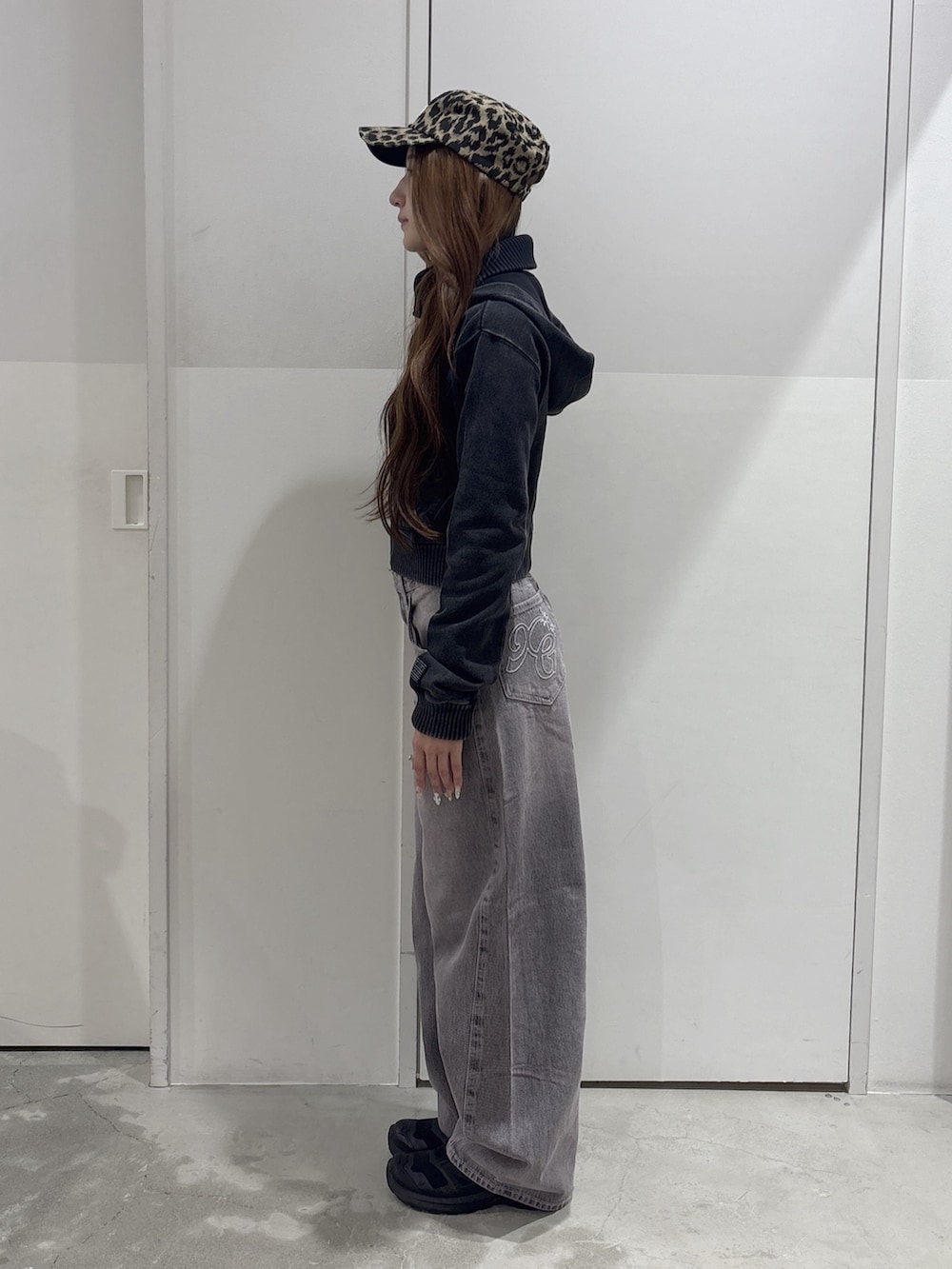 ピンク系のデニムパンツ、ブラック系のブルゾン、ベージュ系のキャップを着用したレディースの秋コーディネートの2枚目の写真