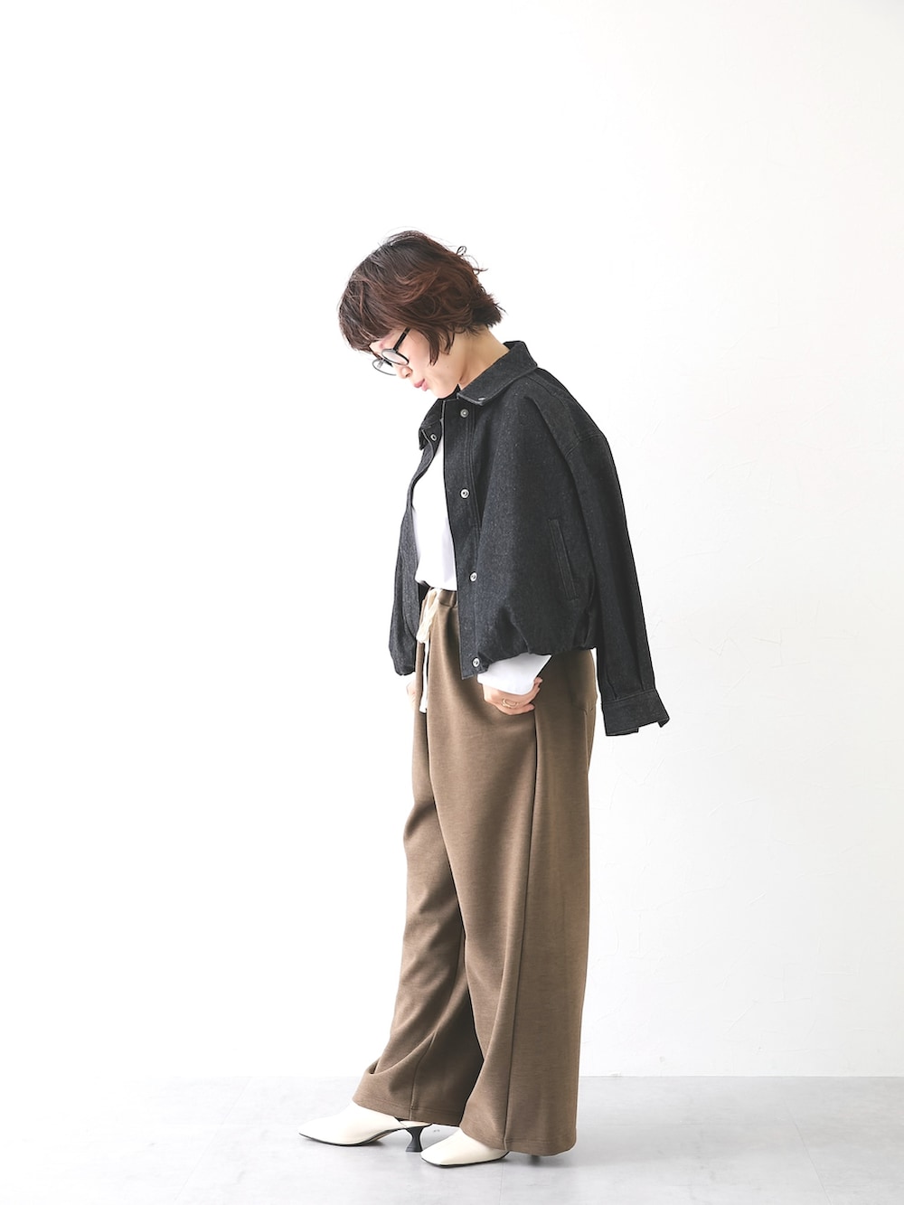 ブラウン系のパンツ、ホワイト系のTシャツ/カットソー、ブラック系のカバーオールを着用したレディースの秋コーディネートの4枚目の写真