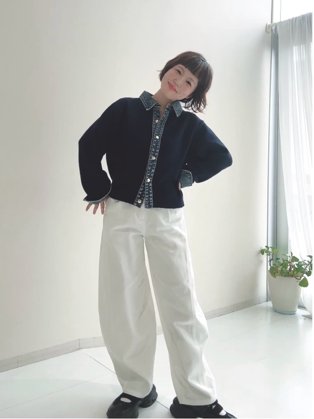 グレー系のニット/セーター、ブルー系のパンツを着用したレディースの秋コーディネートの2枚目の写真