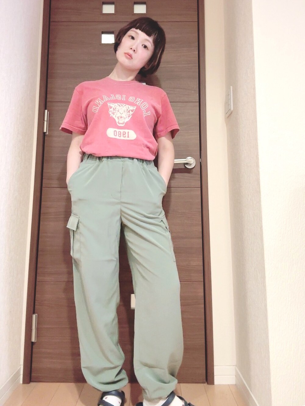 グリーン系のカーゴパンツを着用したレディースの夏コーディネートの2枚目の写真