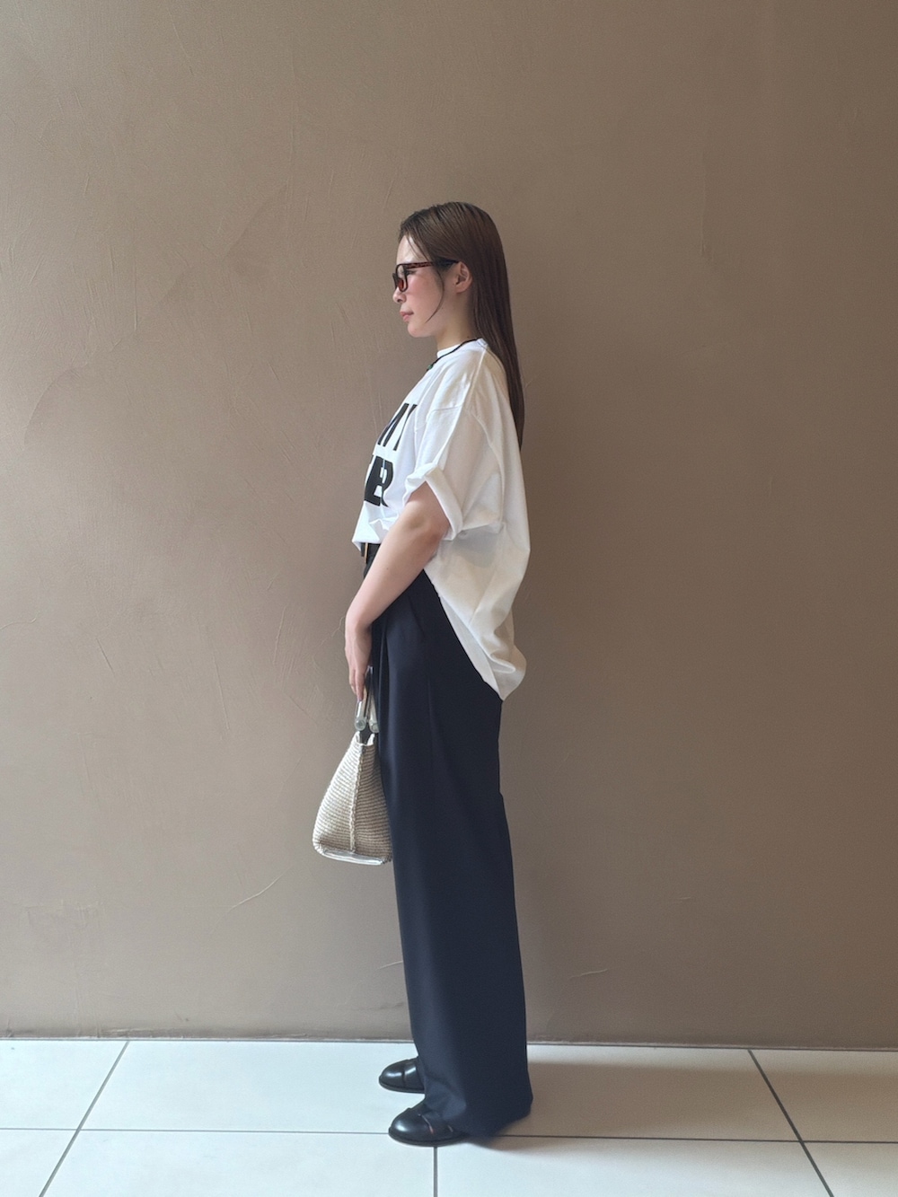 ホワイト系のTシャツ/カットソー、ブルー系のスラックス、ブラック系のサンダルを着用したレディースの夏コーディネートの4枚目の写真