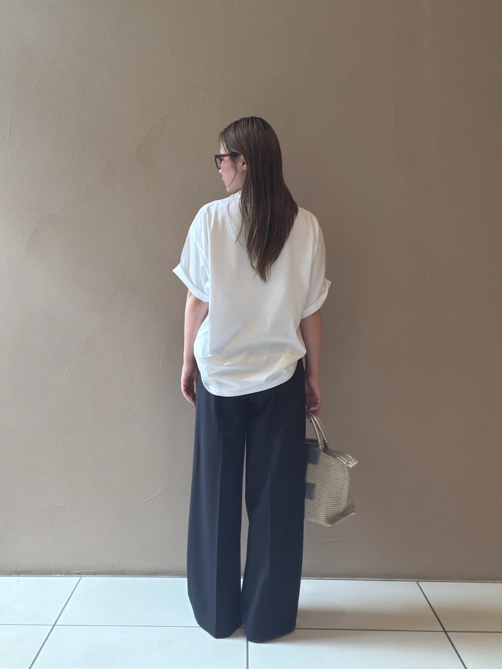 ホワイト系のTシャツ/カットソー、ブルー系のスラックス、ブラック系のサンダルを着用したレディースの夏コーディネートの6枚目の写真