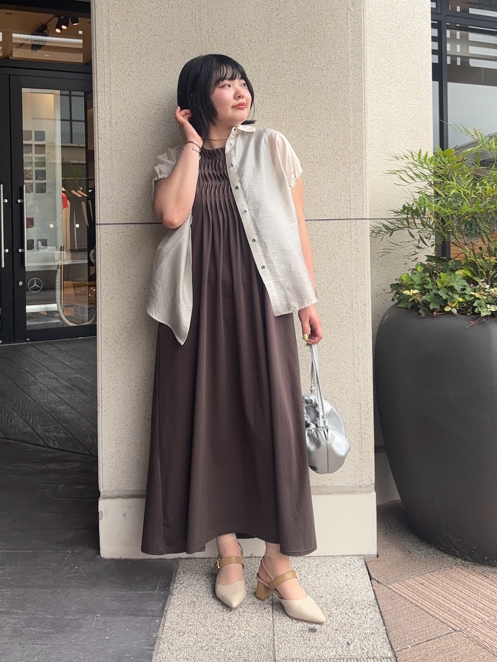 ベージュ系のシャツ/ブラウス、グレー系のワンピース、シルバー系のトートバッグを着用したレディースの夏コーディネートの2枚目の写真