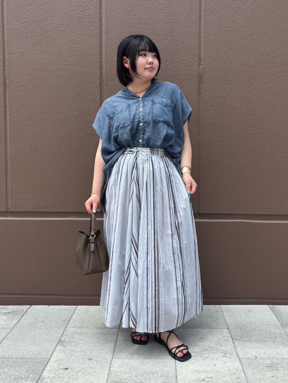 ブルー系のシャツ/ブラウス、ブラック系のスカートを着用したレディースの夏コーディネートの2枚目の写真
