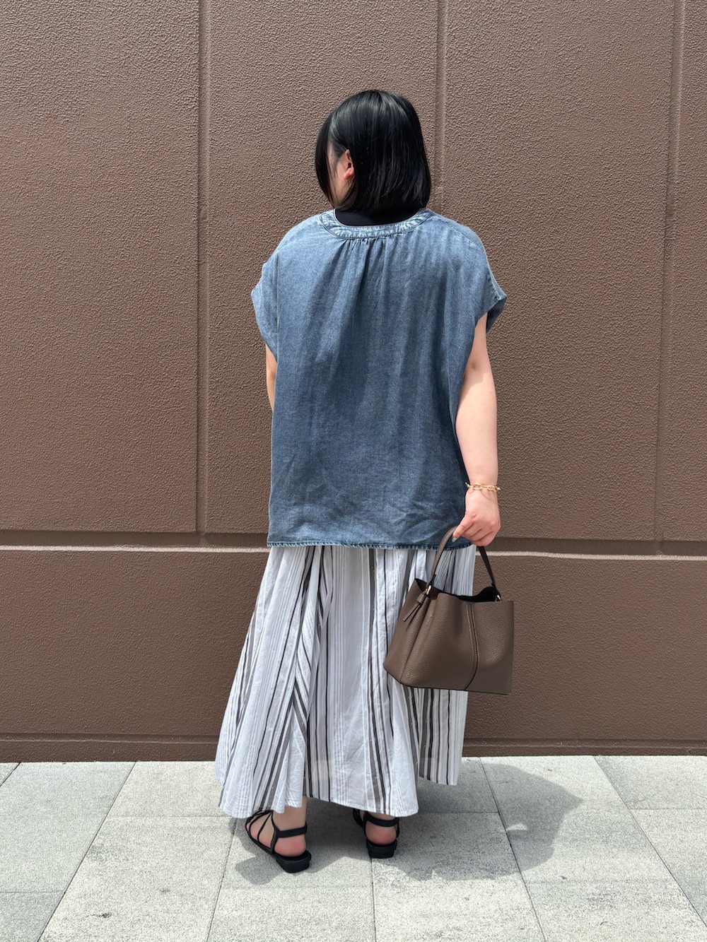 ブルー系のシャツ/ブラウス、ブラック系のスカートを着用したレディースの夏コーディネートの3枚目の写真