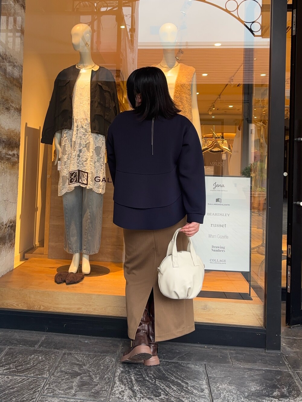 ブルー系のTシャツ/カットソー、ブラウン系のスカート、ホワイト系のトートバッグを着用したレディースの秋コーディネートの3枚目の写真