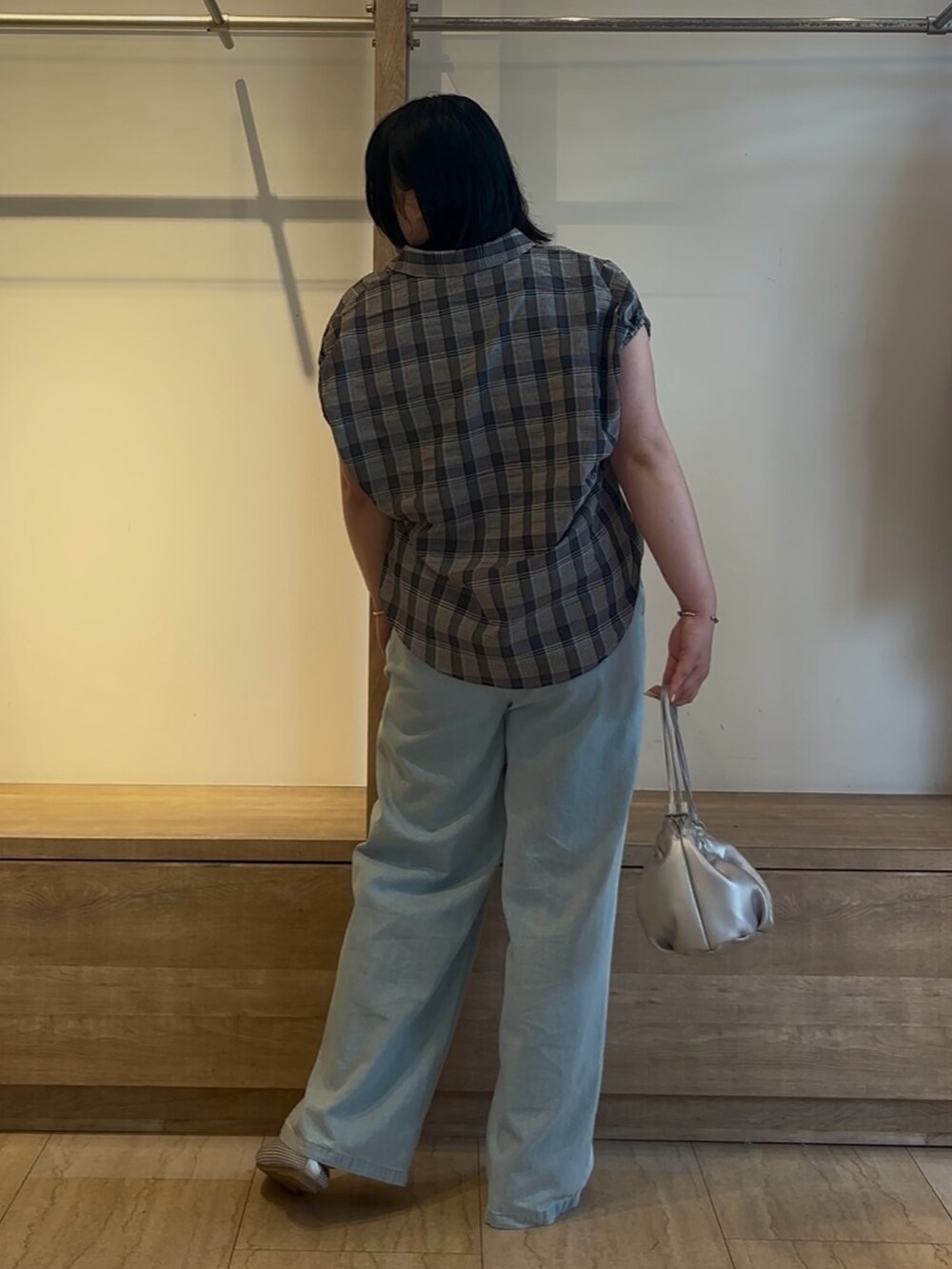 ブルー系のシャツ/ブラウス、ブルー系のデニムパンツ、シルバー系のトートバッグを着用したレディースの夏コーディネートの3枚目の写真