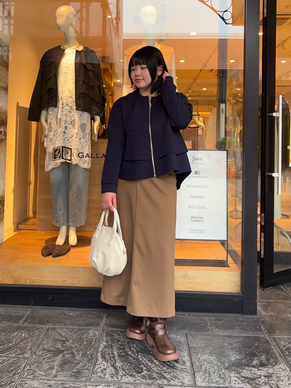ブルー系のTシャツ/カットソー、ブラウン系のスカート、ホワイト系のトートバッグを着用したレディースの秋コーディネートの2枚目の写真