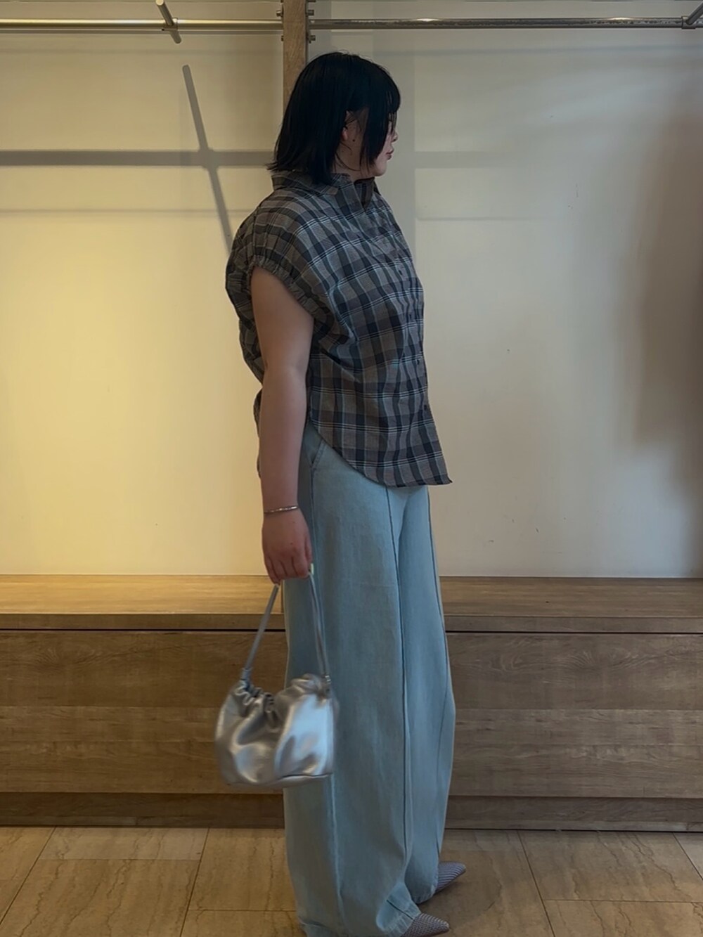 ブルー系のシャツ/ブラウス、ブルー系のデニムパンツ、シルバー系のトートバッグを着用したレディースの夏コーディネートの2枚目の写真