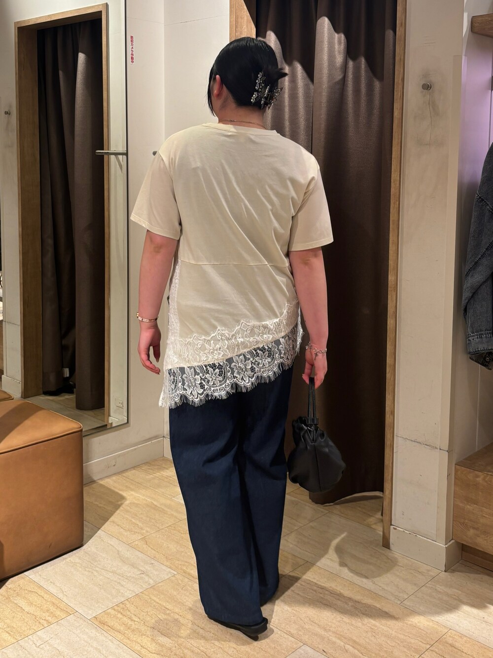 ベージュ系のTシャツ/カットソー、ブルー系のデニムパンツ、ブラック系のトートバッグを着用したレディースの夏コーディネートの2枚目の写真