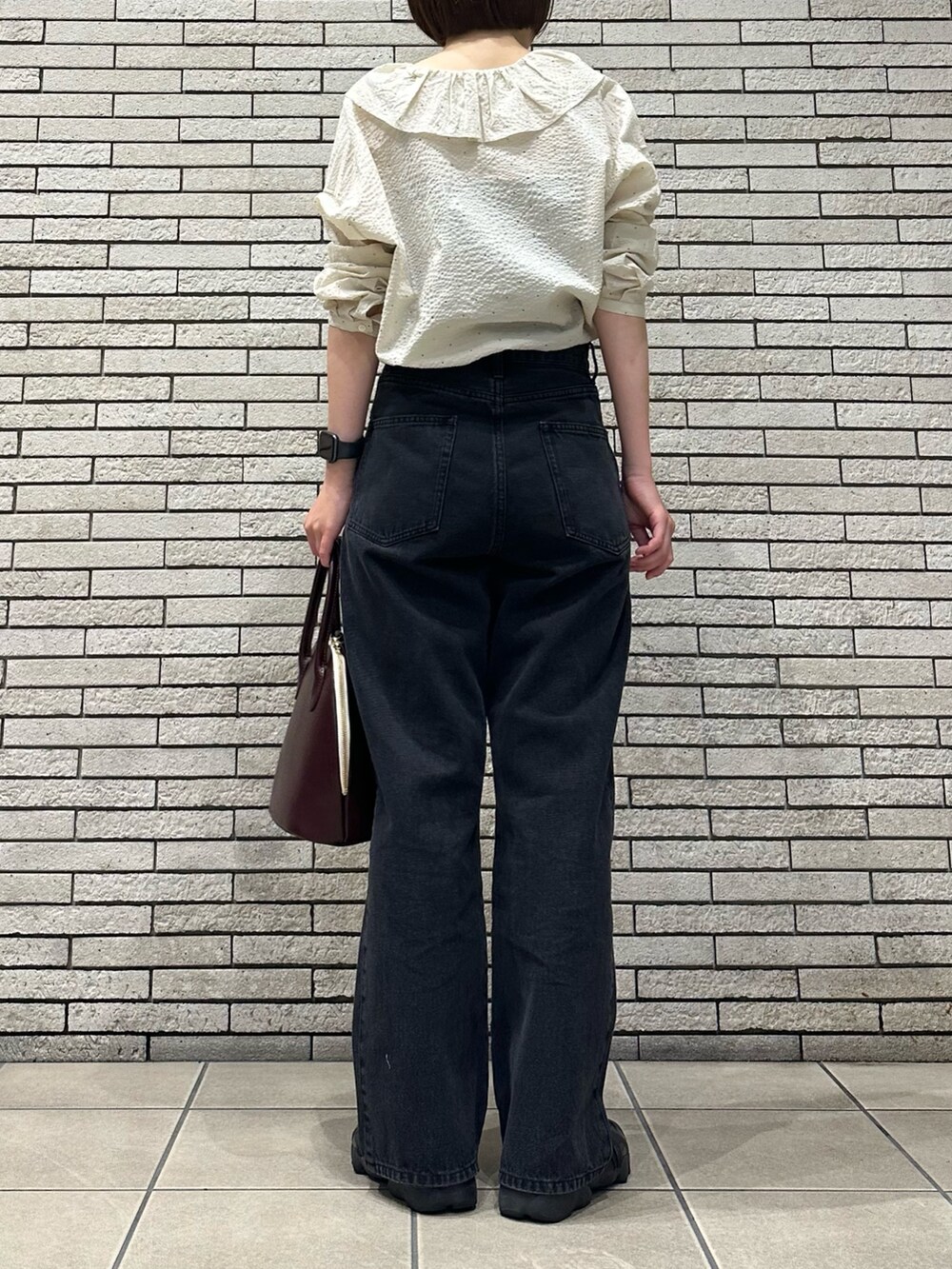 ホワイト系のシャツ/ブラウス、ブラック系のデニムパンツ、レッド系のハンドバッグを着用したレディースの秋コーディネートの4枚目の写真