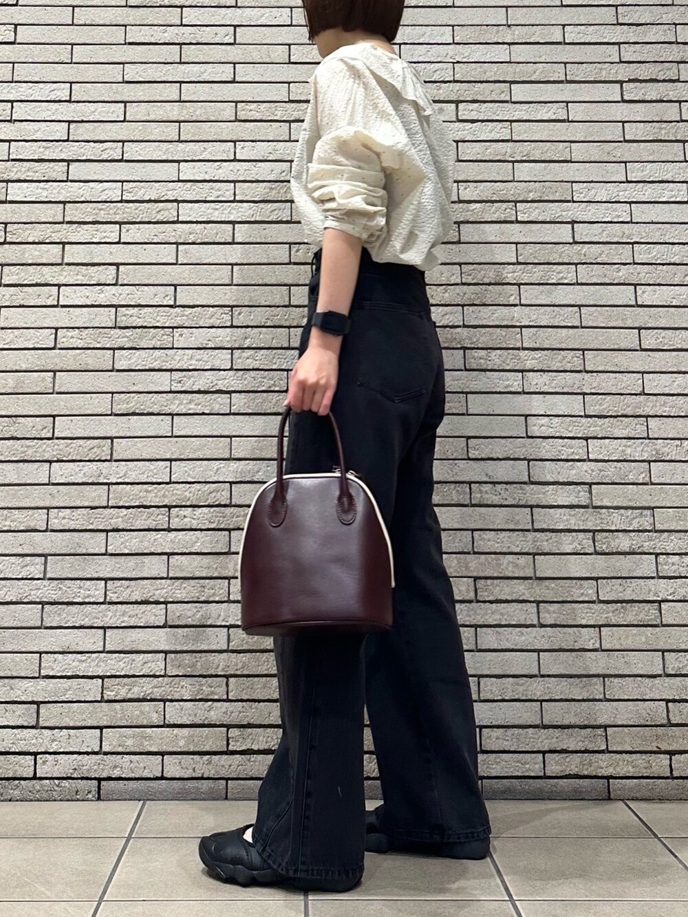ホワイト系のシャツ/ブラウス、ブラック系のデニムパンツ、レッド系のハンドバッグを着用したレディースの秋コーディネートの3枚目の写真