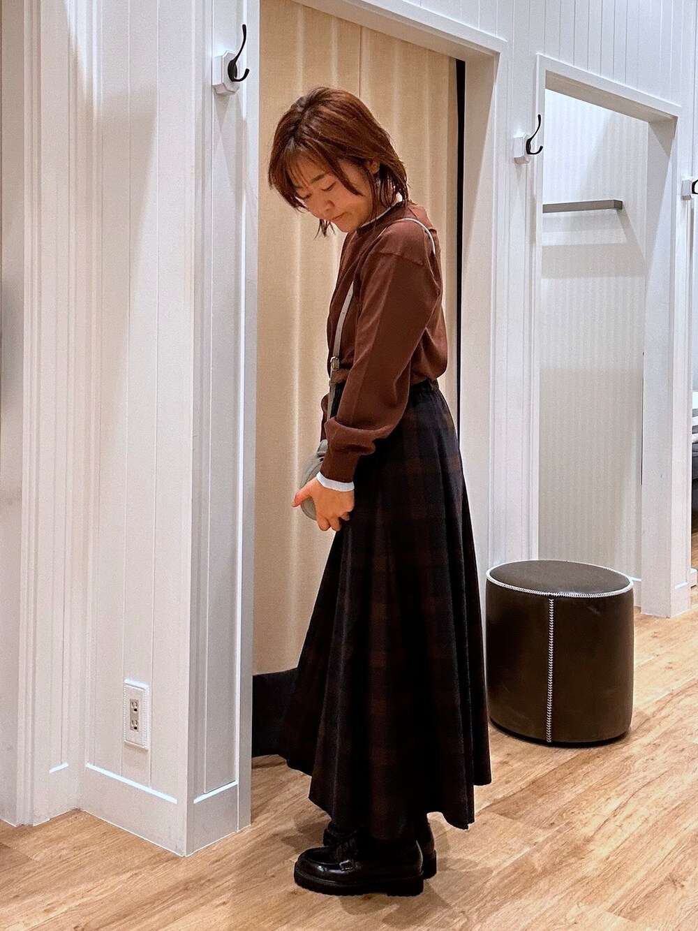 ブルー系のスカート、ブラウン系のニット/セーター、ブラック系のパンプスを着用したレディースの秋コーディネートの7枚目の写真
