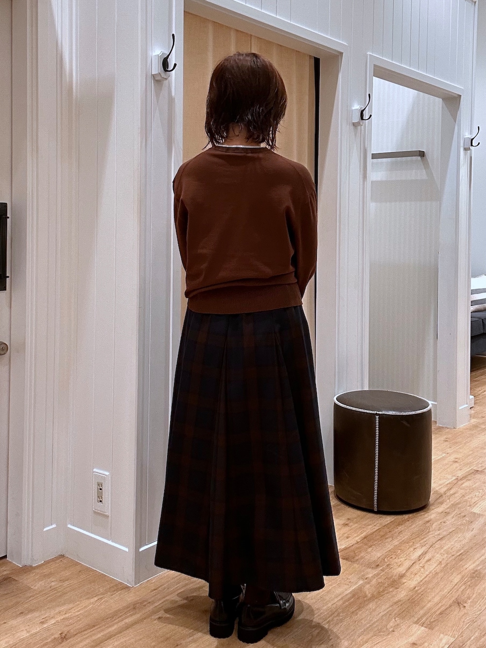ブルー系のスカート、ブラウン系のニット/セーター、ブラック系のパンプスを着用したレディースの秋コーディネートの4枚目の写真