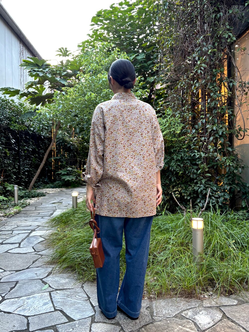 ピンク系のシャツ/ブラウス、ブルー系のデニムパンツ、ブラウン系のローファーを着用したレディースの秋コーディネートの3枚目の写真