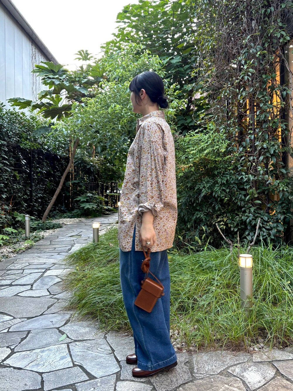 ピンク系のシャツ/ブラウス、ブルー系のデニムパンツ、ブラウン系のローファーを着用したレディースの秋コーディネートの2枚目の写真