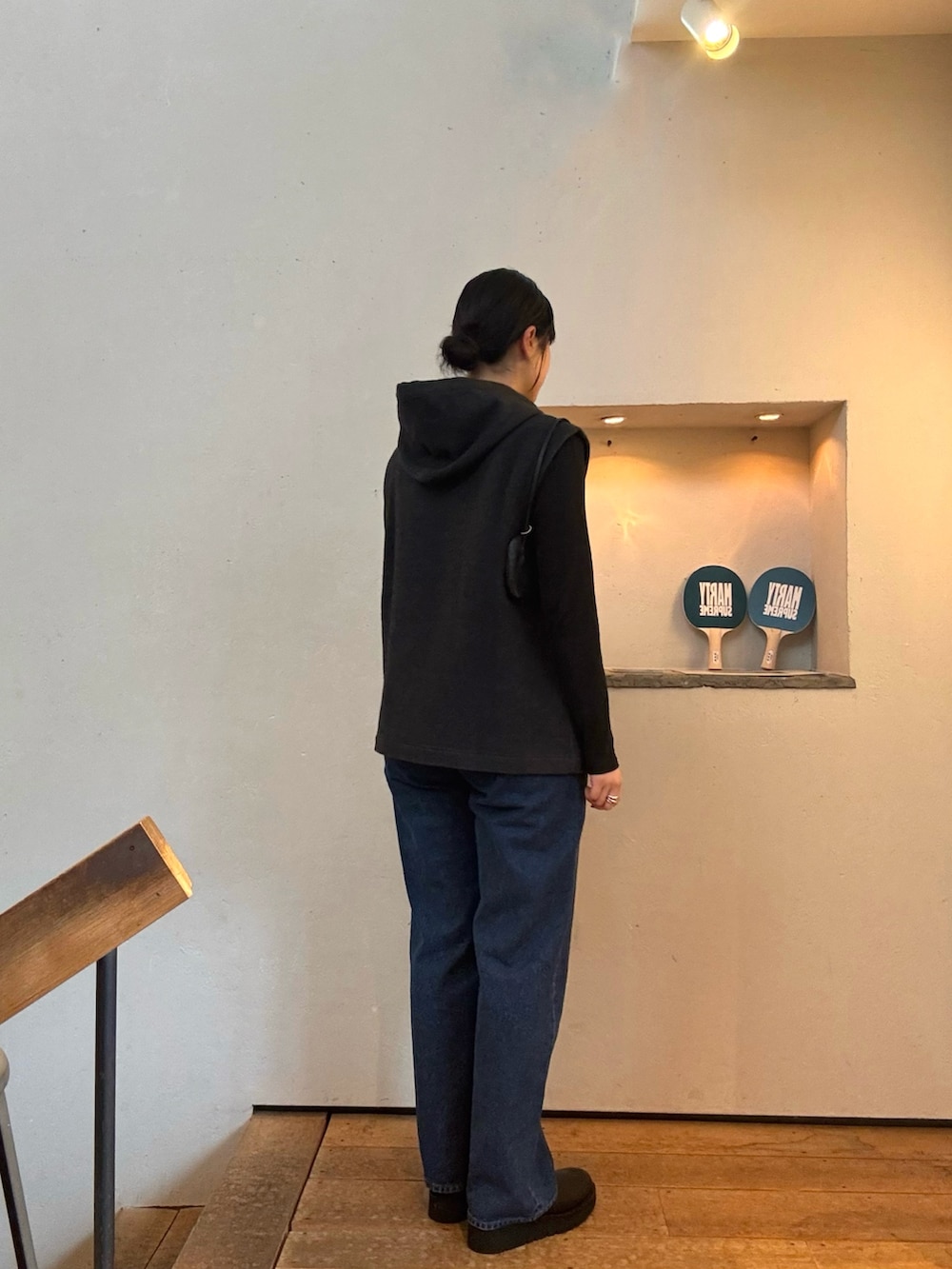 ブラック系のブーツ、グレー系のベスト、ブラック系のショルダーバッグを着用したレディースの秋コーディネートの3枚目の写真