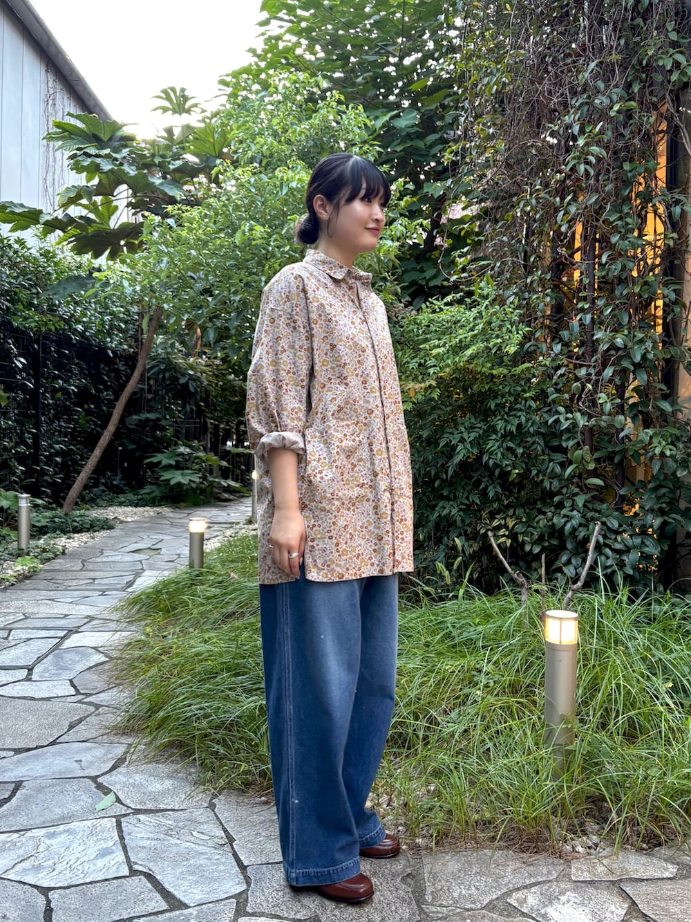ピンク系のシャツ/ブラウス、ブルー系のデニムパンツ、ブラウン系のローファーを着用したレディースの秋コーディネートの4枚目の写真