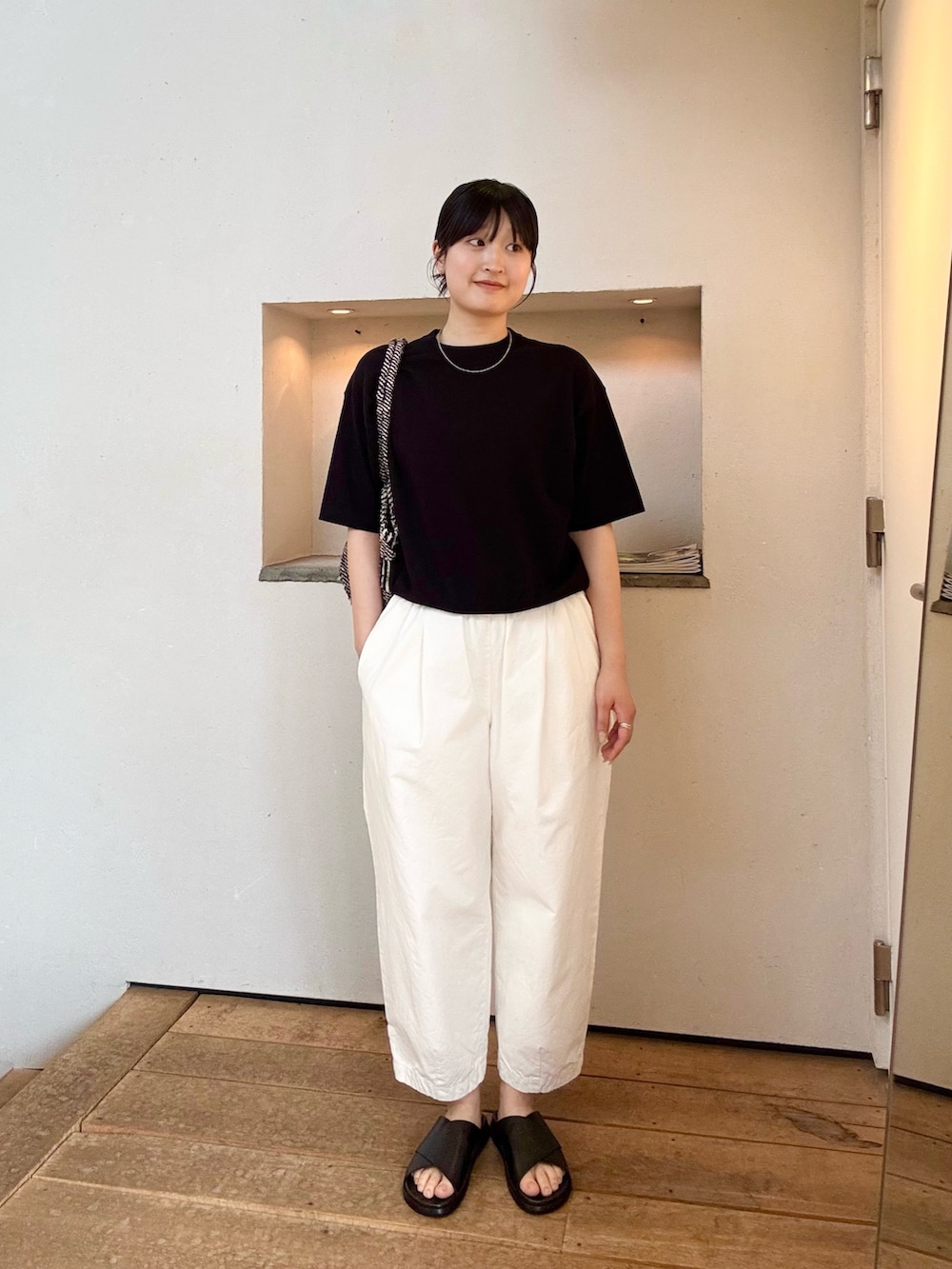 ホワイト系のその他パンツ、ブラック系のサンダル、ブラック系のニット/セーターを着用したレディースの夏コーディネートの2枚目の写真