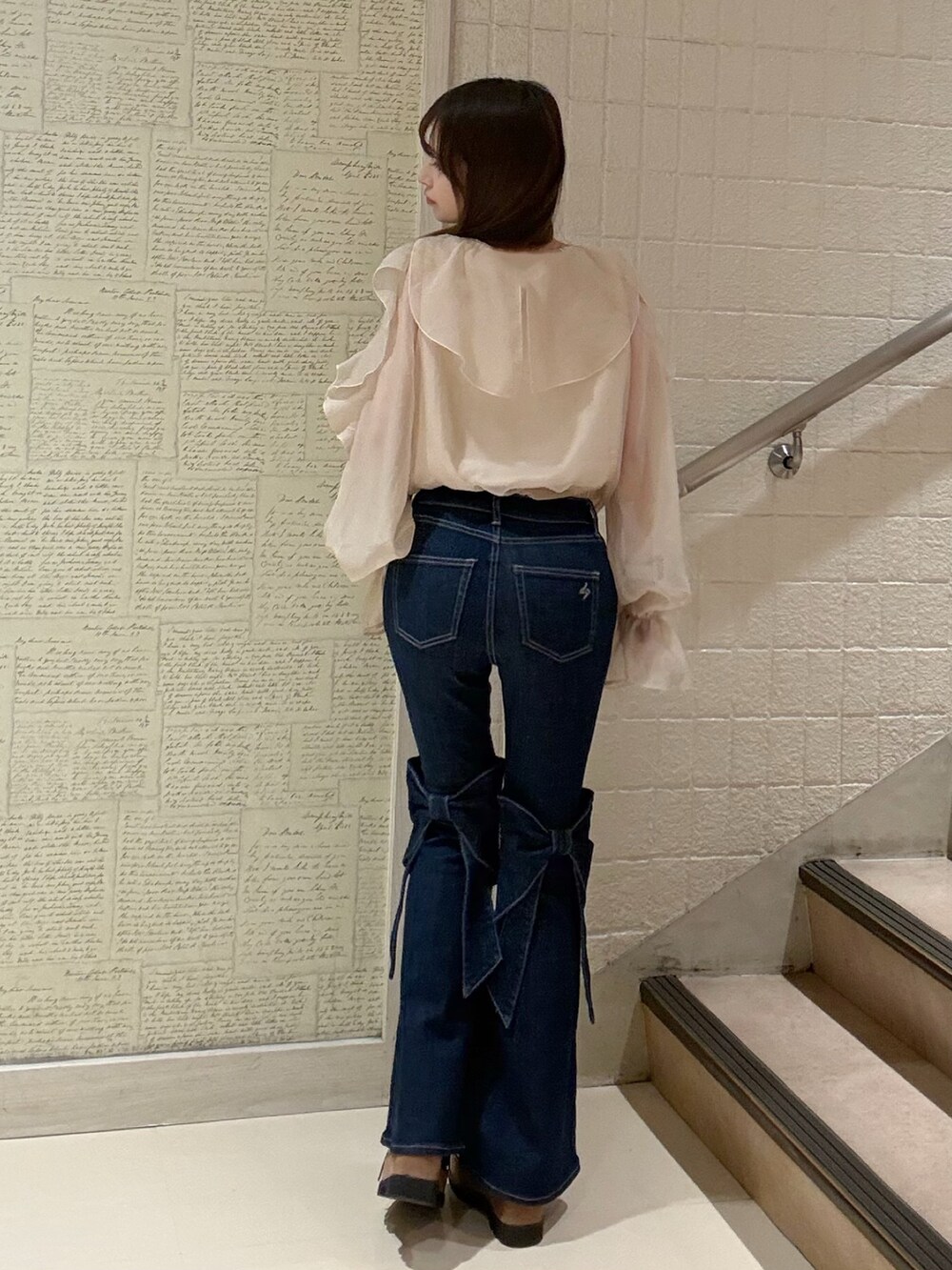 ブルー系のデニムパンツ、オレンジ系のシャツ/ブラウスを着用したレディースの春コーディネートの6枚目の写真