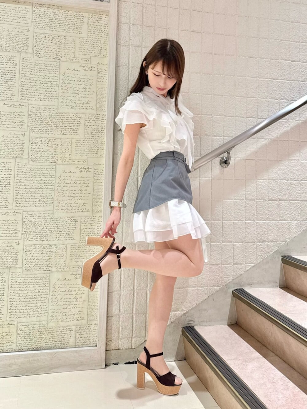 ブラウン系のサンダル、グレー系のスカート、ホワイト系のハンドバッグを着用したレディースの夏コーディネートの4枚目の写真