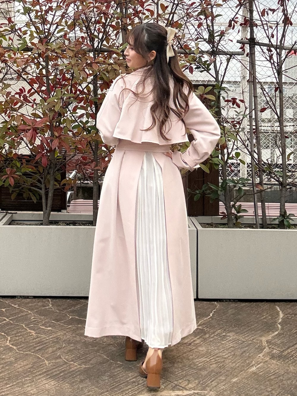 ピンク系のトレンチコート、ブラウン系のパンプスを着用したレディースの冬コーディネートの4枚目の写真