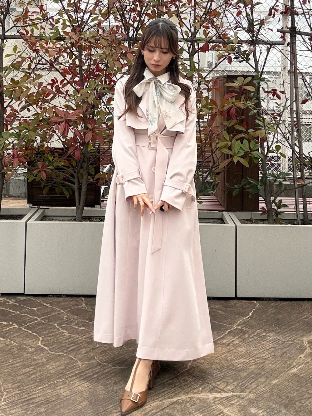 ピンク系のトレンチコート、ブラウン系のパンプスを着用したレディースの冬コーディネートの3枚目の写真