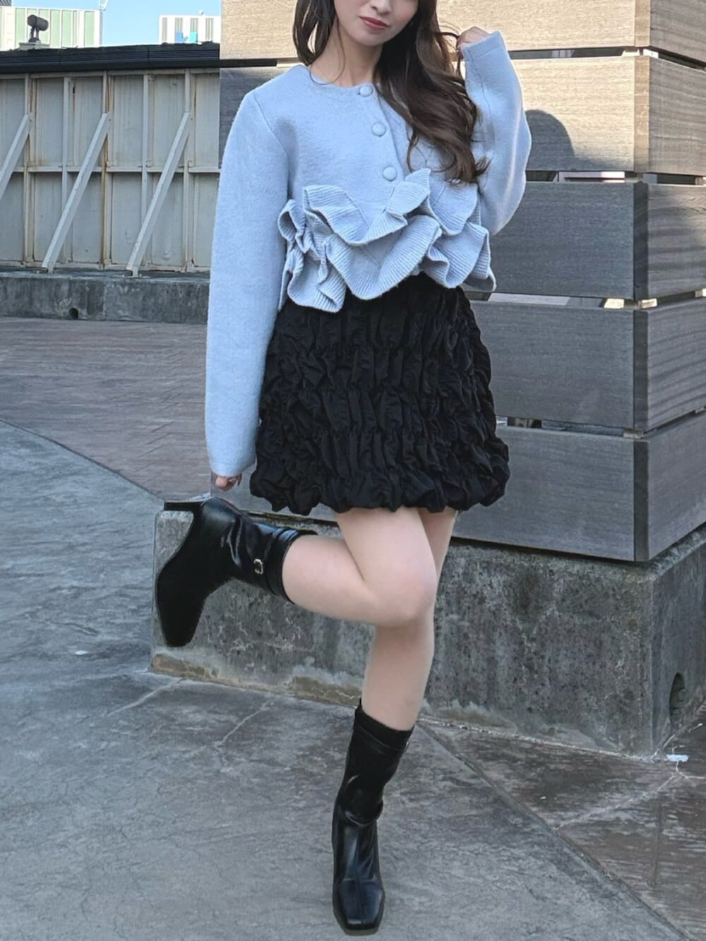 ブルー系のノーカラージャケット、ブラック系のスカート、ブラック系のブーツを着用したレディースの冬コーディネートの2枚目の写真