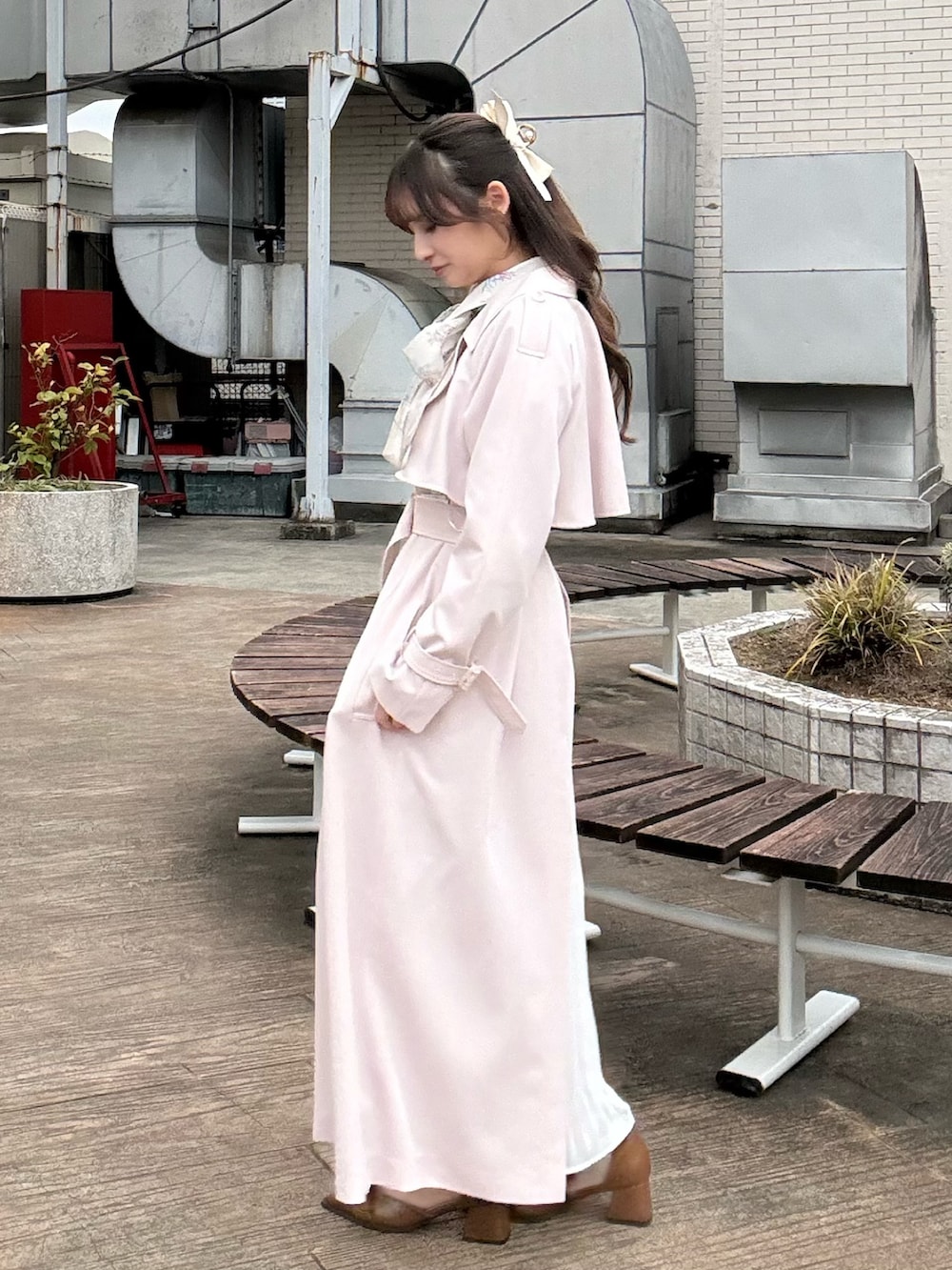 ピンク系のトレンチコート、ブラウン系のパンプスを着用したレディースの冬コーディネートの5枚目の写真