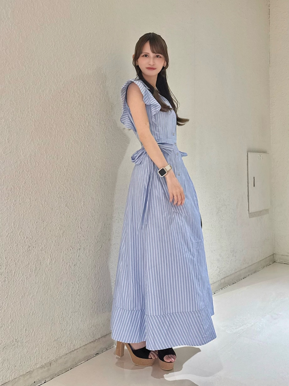 ブルー系のワンピース、ブラウン系のハンドバッグ、ブラウン系のサンダルを着用したレディースの夏コーディネートの3枚目の写真