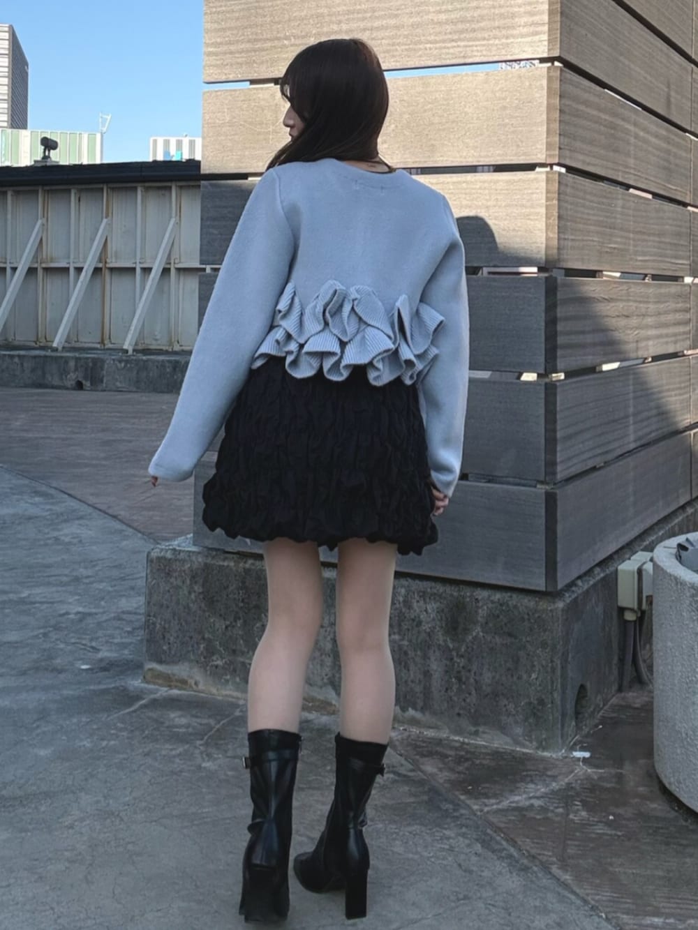 ブルー系のノーカラージャケット、ブラック系のスカート、ブラック系のブーツを着用したレディースの冬コーディネートの5枚目の写真