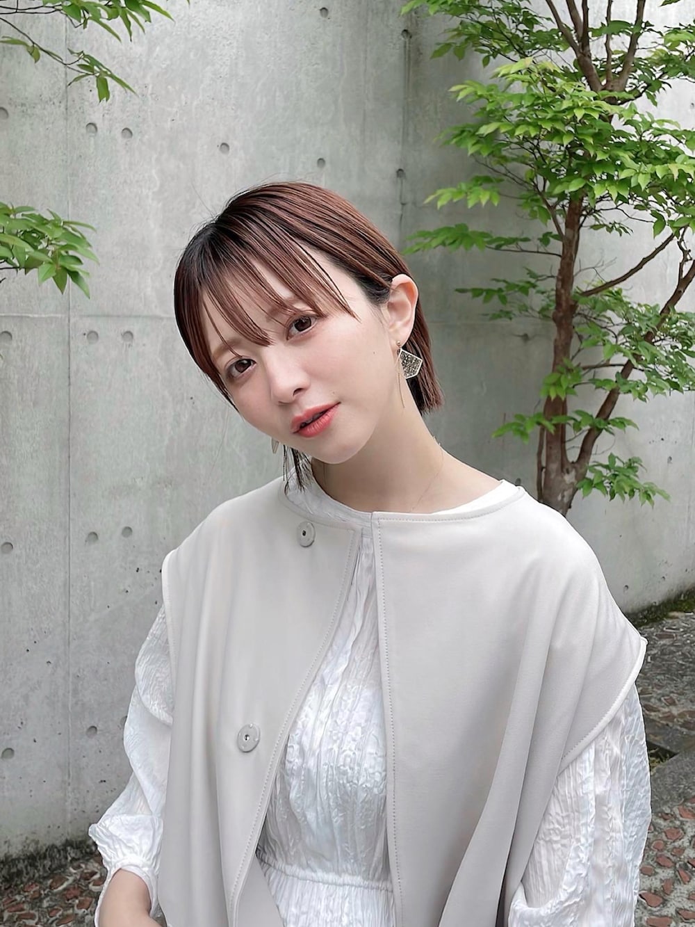 ホワイト系のワンピース、ホワイト系のベストを着用したレディースの春コーディネートの2枚目の写真