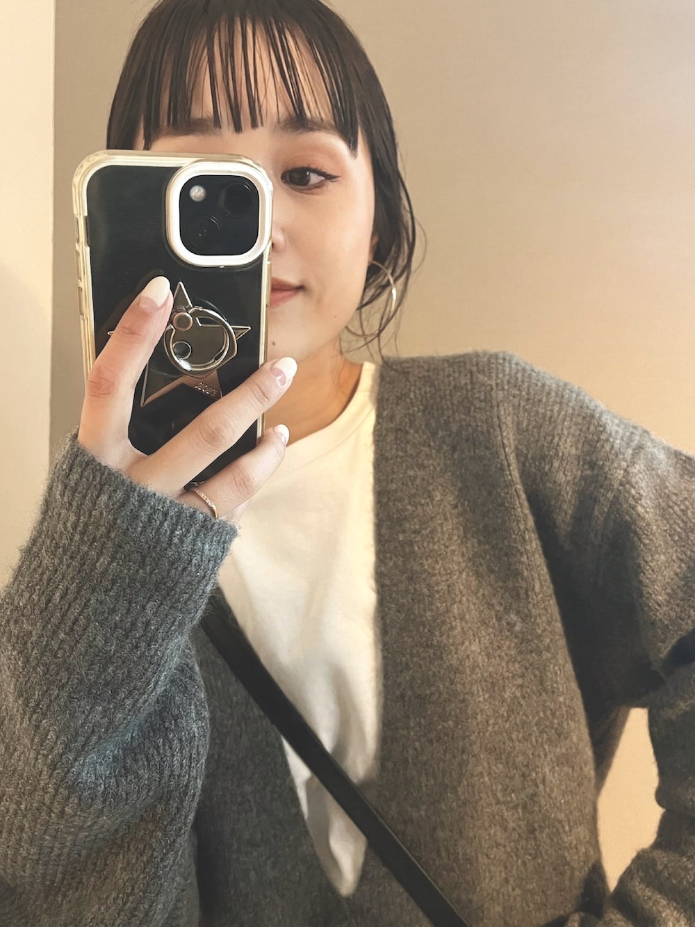 グレー系のニット/セーター、ブラック系のショルダーバッグを着用したレディースの春コーディネートの2枚目の写真