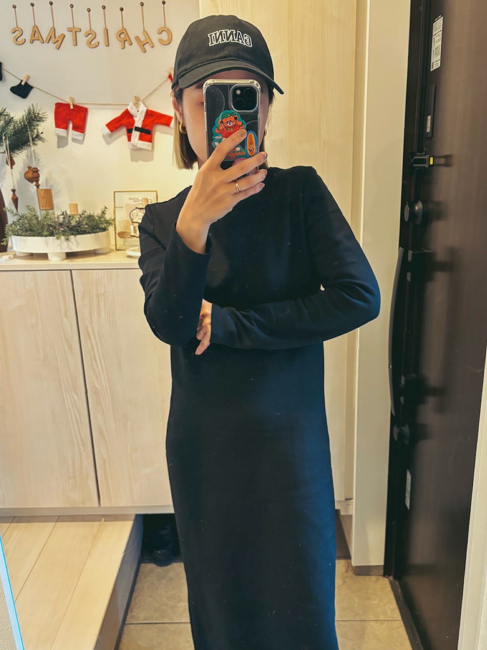 ブラック系のワンピース、ベージュ系のスニーカー、ブラック系のキャップを着用したレディースの春コーディネートの2枚目の写真