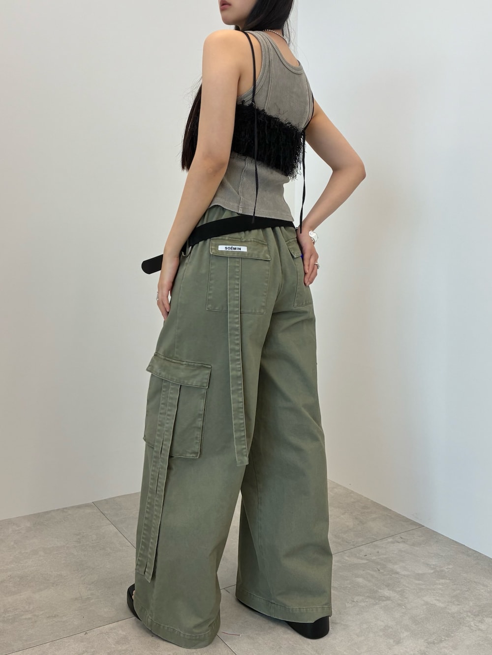グレー系のタンクトップ、グリーン系のカーゴパンツ、シルバー系のバングル/リストバンドを着用したレディースの夏コーディネートの4枚目の写真