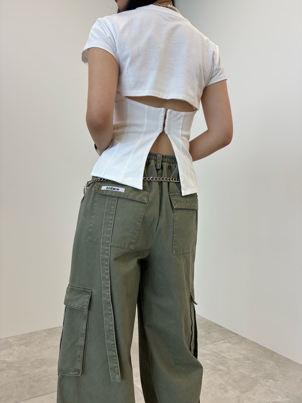 グリーン系のカーゴパンツ、ホワイト系のTシャツ/カットソー、シルバー系のベルトを着用したレディースの夏コーディネートの5枚目の写真