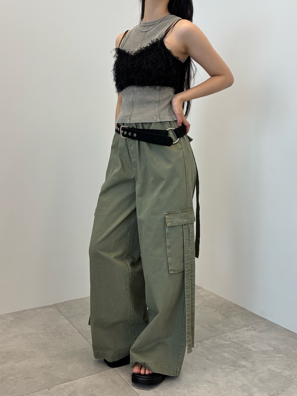 グレー系のタンクトップ、グリーン系のカーゴパンツ、シルバー系のバングル/リストバンドを着用したレディースの夏コーディネートの3枚目の写真