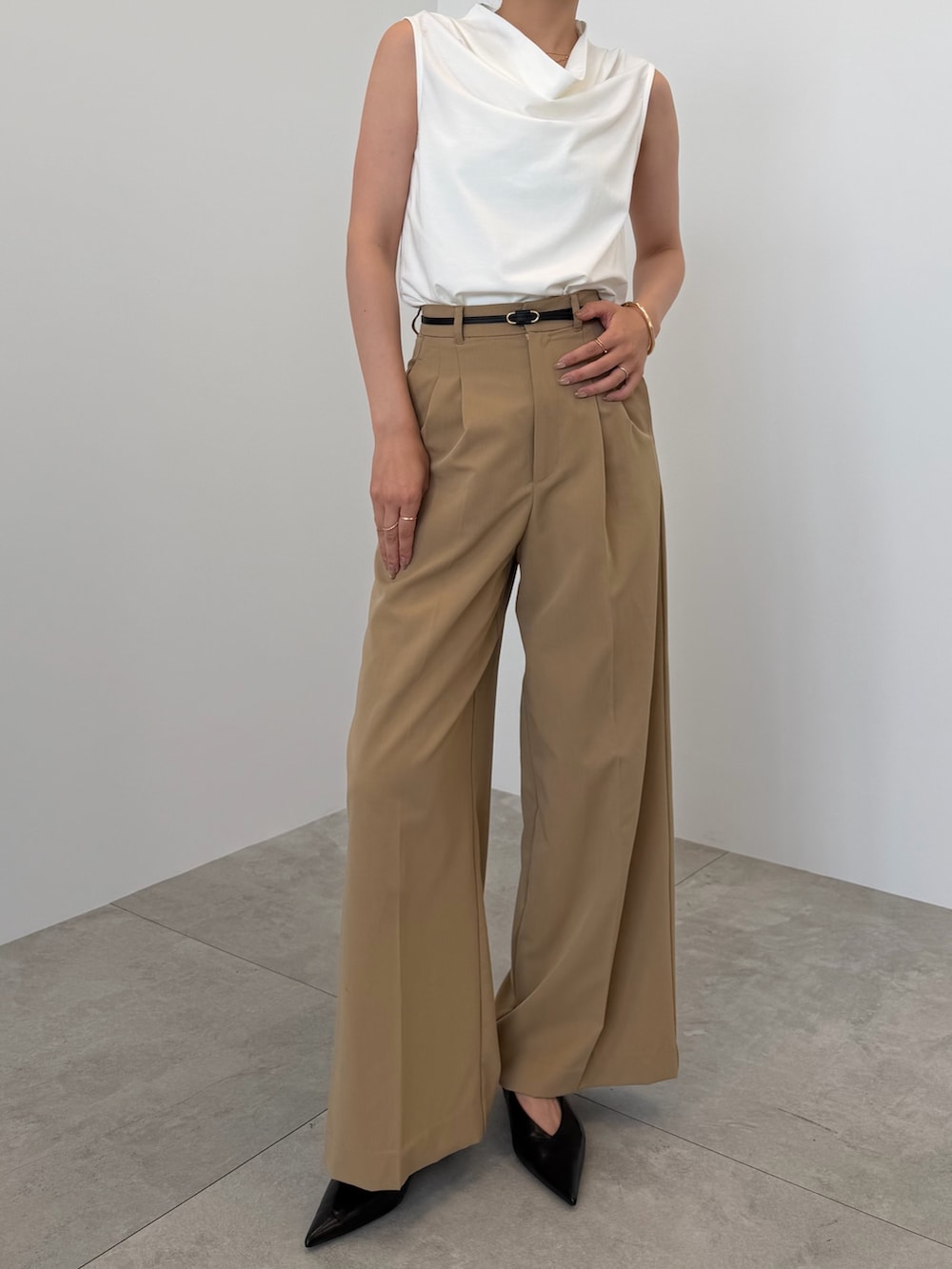 ホワイト系のTシャツ/カットソー、ベージュ系のスラックス、ブラック系のベルトを着用したレディースの夏コーディネートの2枚目の写真