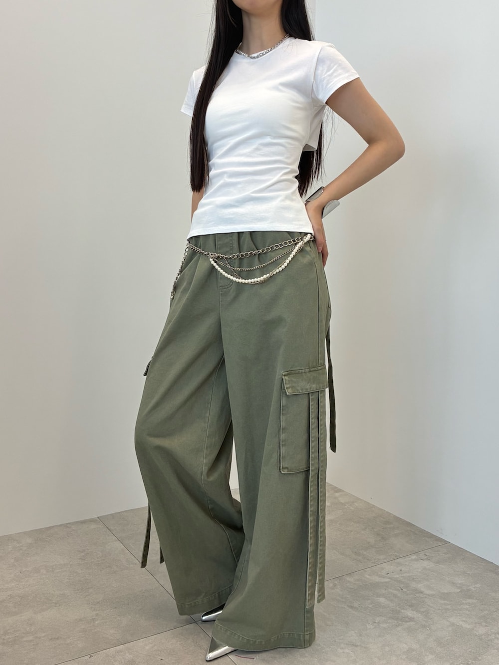 グリーン系のカーゴパンツ、ホワイト系のTシャツ/カットソー、シルバー系のベルトを着用したレディースの夏コーディネートの3枚目の写真