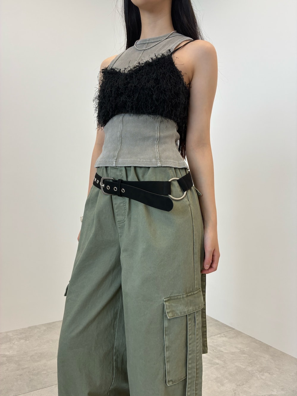 グレー系のタンクトップ、グリーン系のカーゴパンツ、シルバー系のバングル/リストバンドを着用したレディースの夏コーディネートの5枚目の写真