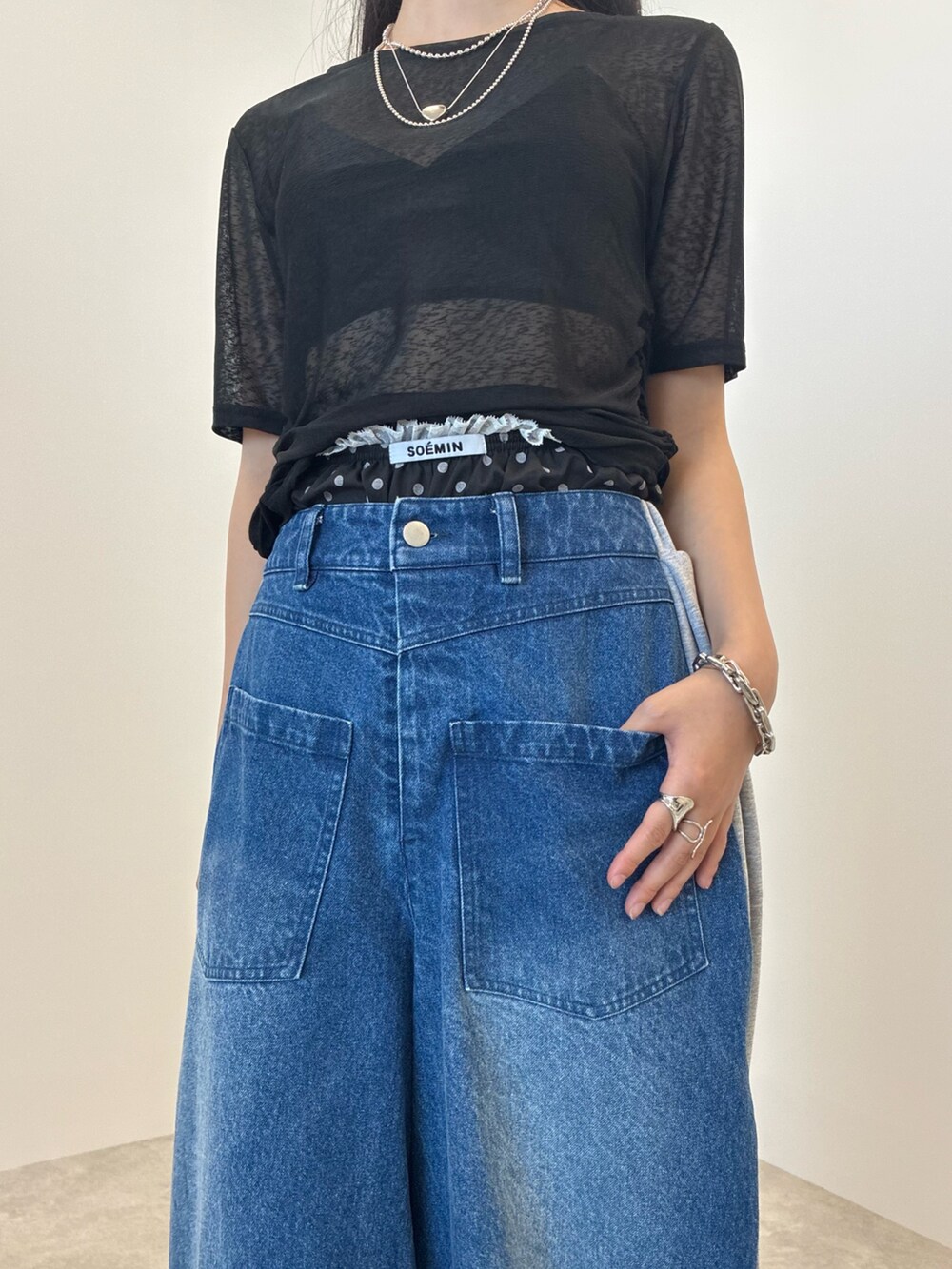 ブルー系のデニムパンツ、ブラック系のTシャツ/カットソー、シルバー系のネックレスを着用したレディースの夏コーディネートの4枚目の写真