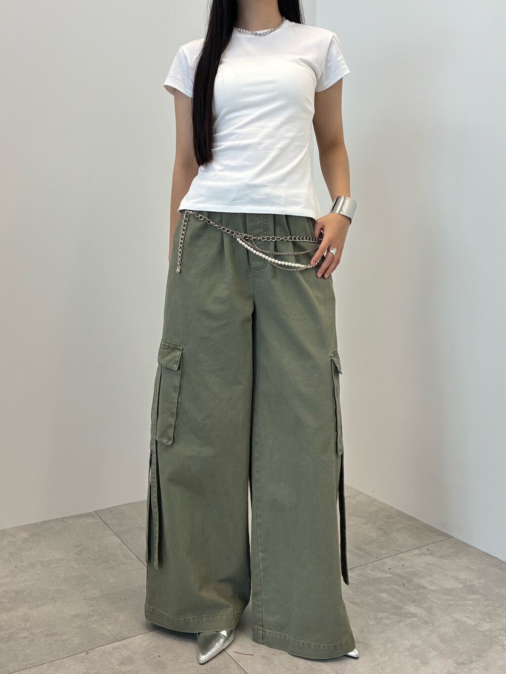 グリーン系のカーゴパンツ、ホワイト系のTシャツ/カットソー、シルバー系のベルトを着用したレディースの夏コーディネートの2枚目の写真