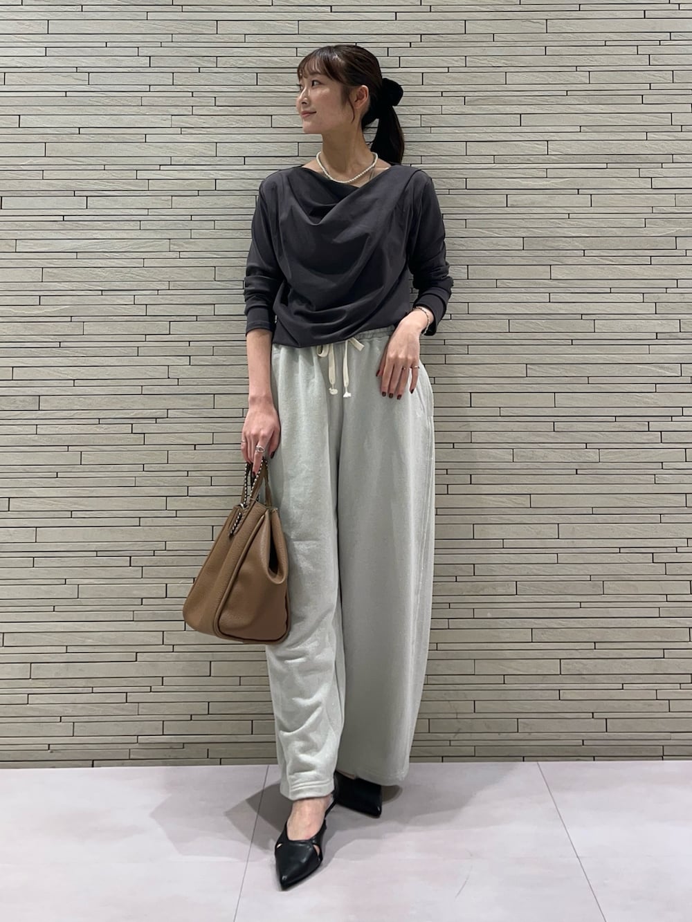 グレー系のTシャツ/カットソー、ホワイト系のスウェットパンツ、イエロー系のトートバッグを着用したレディースの秋コーディネートの5枚目の写真