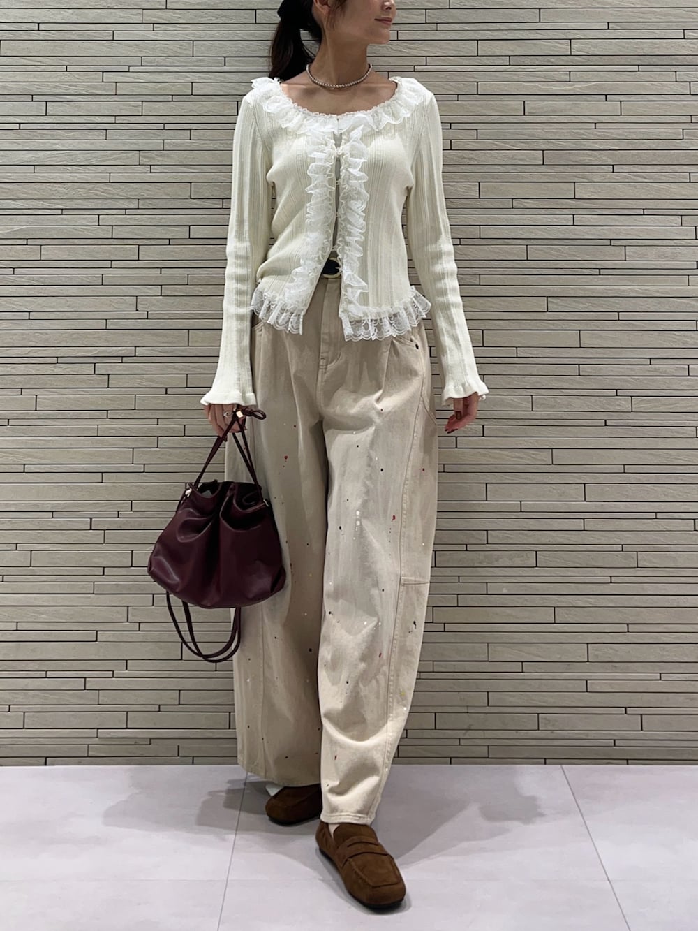 ホワイト系のカーディガン/ボレロ、ベージュ系のその他パンツ、レッド系のトートバッグを着用したレディースの秋コーディネートの5枚目の写真